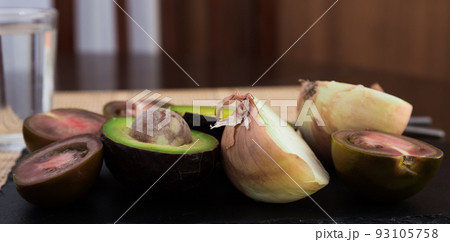 vegetables black tomatoes, avocado and onions on black stone board vegetables black tomatoes, avocado and onions on black stone board 93105758