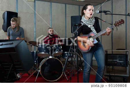 Attractive guitar player and singer with band 93109808
