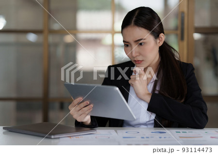 Image of Asian Business woman stressed while analyzing financial report balance. Financial and investment concept. 93114473
