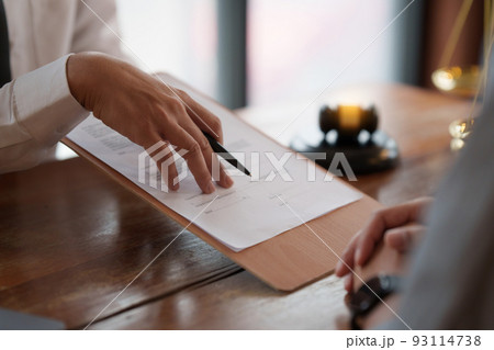 Business person and lawyers discussing contract papers with brass scale on wooden desk in office. Law, legal services, advice, Justice concept. Business person and lawyers discussing contract papers with brass scale on wooden desk in office. Law, legal services, advice, Justice concept. 93114738