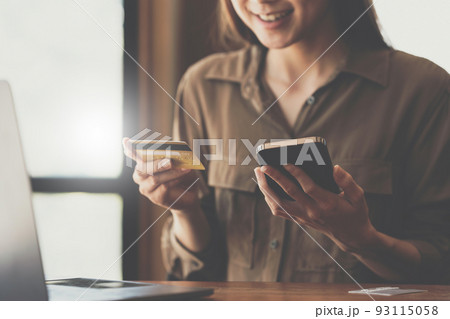 Woman using online payment and holding credit card. Online Shopping concept. 93115058