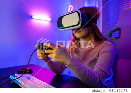 Gamer in VR headset glasses exploring metaverse play video game online with joystick Gamer in VR headset glasses exploring metaverse play video game online with joystick 93115171