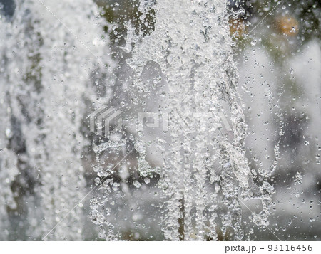Splashes of water on dark background. Water sprays in sunny day close-up. Splashes of water on dark background. Water sprays in sunny day close-up. 93116456