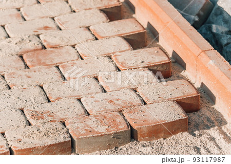 Brown concrete permeable flooring assembled on a substrate of sand. Abstract photo of bricks in the sunlight 93117987