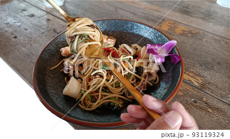 Use a spoon and fork to roll hot spicy spaghetti with seafood 93119324