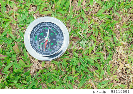 The compass is placed on the green grass showing north south  east west 93119691