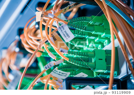 detail of server rack with fiber optic cables attached to front panel switch ports 93119909