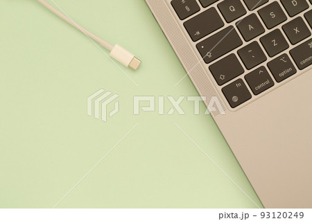 usb c cable and laptop keyboard on green background 93120249