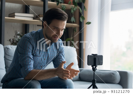 Man makes speech sit on sofa in front of smartphone 93121270