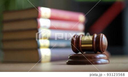 Judge hammer with golden strip on sounding block and books Judge hammer with golden strip on sounding block and books 93123568
