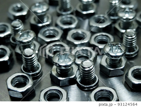 Threaded connection. Bolts and nuts on aluminum surface macro shot 93124564