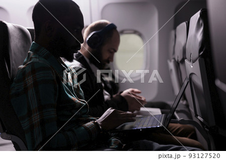 Multiethnic group of people travelling abroad by airplane, flying with international airline in economy class. Going on holiday vacation or business trip with plane tarnsportation service. 93127520