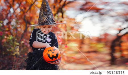 Young girl in black costume goes trick or treating Young girl in black costume goes trick or treating 93128553