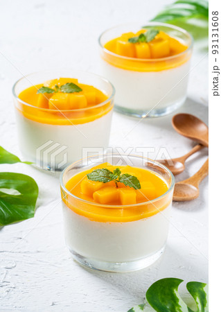 Delicious double colored mango panna cotta mousse pudding on white table background. 93131608