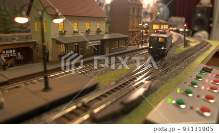 Model train with wagons is driving on model railroad. Railway station. Model train with wagons is driving on model railroad. Railway station. 93131905
