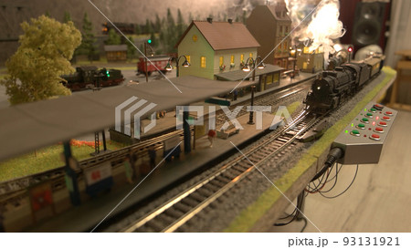 Miniature train railway station. A model of a train moves down the miniature railroad. Miniature of city. Miniature train railway station. A model of a train moves down the miniature railroad. Miniature of city. 93131921