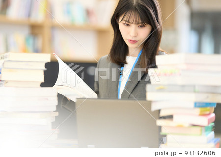 PCの画面と資料を見ながら調べ物をする若いビジネスウーマン PCの画面と資料を見ながら調べ物をする若いビジネスウーマン 93132606