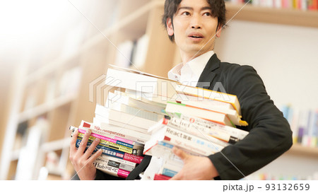 たくさんの書籍を両手で抱える男性 93132659