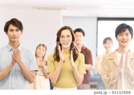 笑顔で拍手をする若い男女 93132666