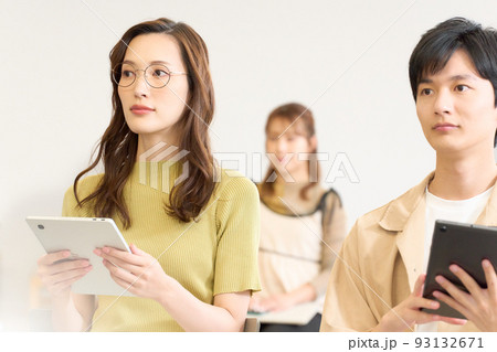 タブレットを持ちながらセミナーを受講する若い男女 93132671