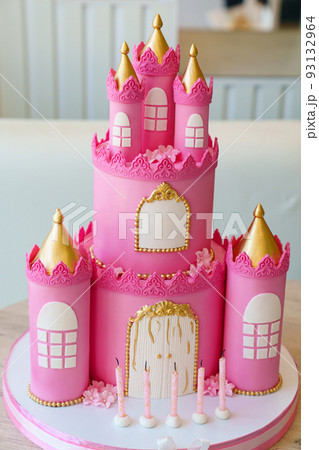 five pink candles on the cake in the form of a fairytale castle.  93132964