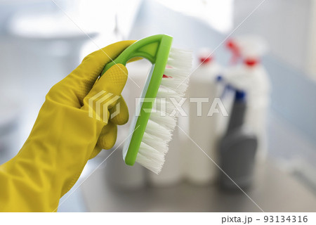 girl in rubber gloves with a brush does cleaning in the bathroom girl in rubber gloves with a brush does cleaning in the bathroom 93134316
