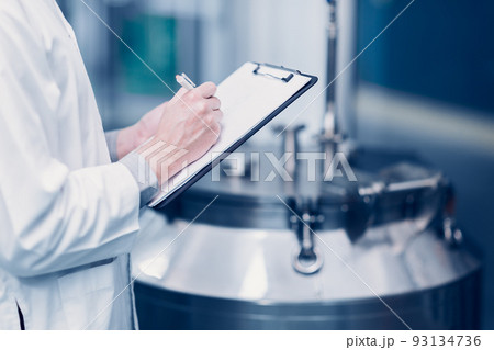 medicine science factory staff worker check quality products sterilize in autoclave tank in check list. 93134736