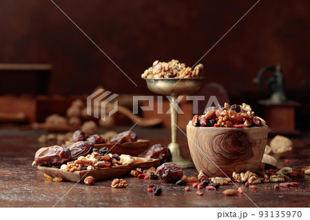 Various dried fruits and nuts on a kitchen table. Various dried fruits and nuts on a kitchen table. 93135970