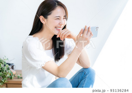スマホで視聴する若い女性 スマホで視聴する若い女性 93136284