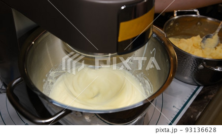 Male hands add the ingredient cream for baking in the bowl of a food processor. Crash with paddle adding cream. Safety first 93136628