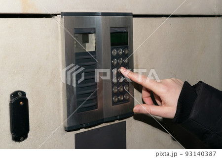 Hands Pressing on Intercom 93140387