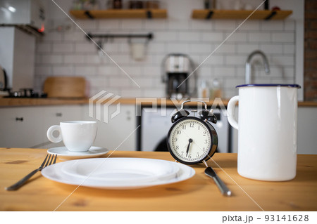 intermittent fasting concept alarm clock on kitchen table intermittent fasting concept alarm clock on kitchen table 93141628