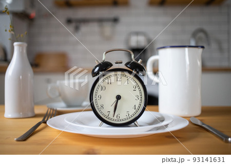 intermittent fasting concept alarm clock on kitchen table 93141631