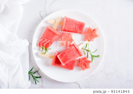 Watermelon popsicle and pieces of watermelon on a plate on the table. Homemade dessert. Top view 93141843