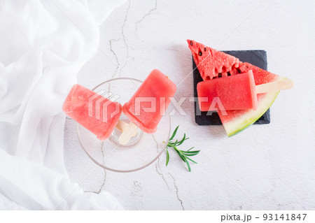 Watermelon popsicles in a bowl and a piece of watermelon on the table. Homemade dessert. Top view 93141847
