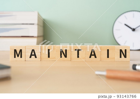 維持・継続のイメージ｜「MAINTAIN」と書かれたブロックが置かれたデスク 93143766