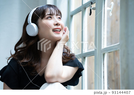 ヘッドフォンで音楽を聴く若い女性 93144407