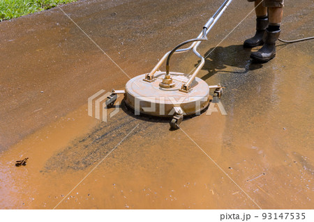 With a sweeper machine, a worker washed the road in order to keep it clean 93147535