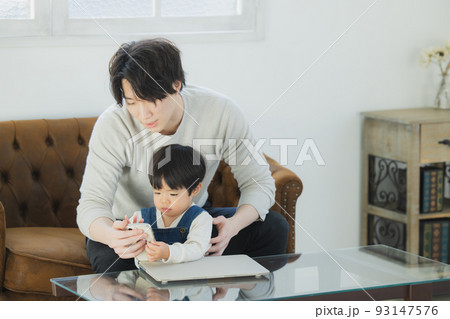 パソコンを見るパパと小さな男の子 93147576