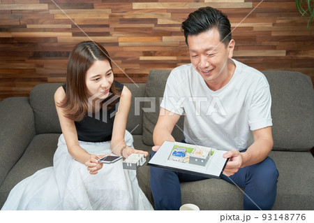 部屋で住宅の模型を見る男女 93148776