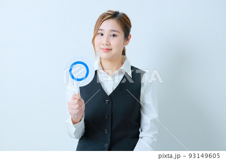 右手で○プレートを持った微笑む若いOL 93149605