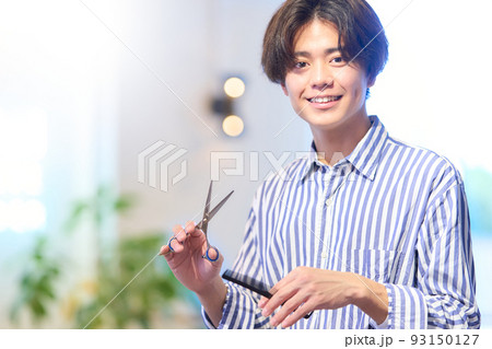 笑顔で視線を向けるヘアスタイリスト 93150127