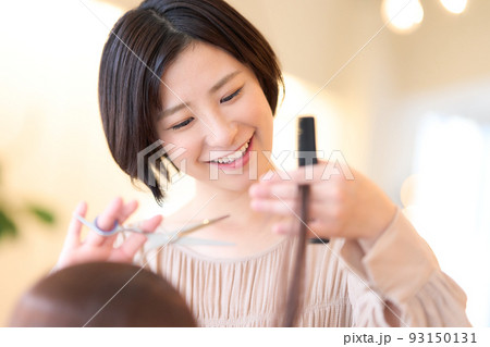 美容室でお客の髪をカットする女性ヘアスタイリスト 93150131