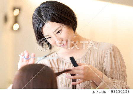 美容室でお客の髪をカットする女性ヘアスタイリスト 美容室でお客の髪をカットする女性ヘアスタイリスト 93150133