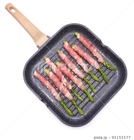 aspargus covered with bacon in a grill frying pan isolated on white background 93155577