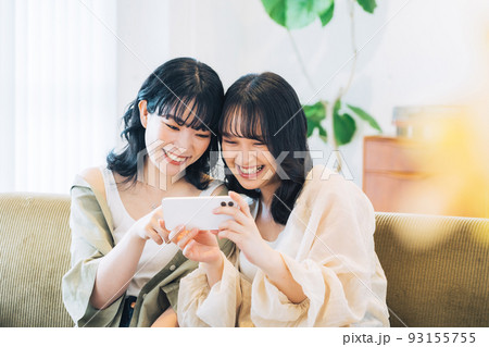スマホを見る笑顔の女性2人組 スマホを見る笑顔の女性2人組 93155755