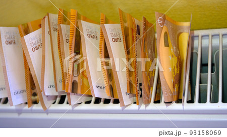 Euro banknotes in central heating radiator, concept of expensive heating costs, close-up. Crisis of energy resources in the world. 93158069