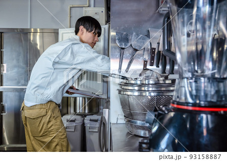 業務用厨房器具を確認する男性スタッフ　業務用冷蔵庫 93158887