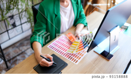 Woman interior designer working with fan of colourful samples in office 93158888