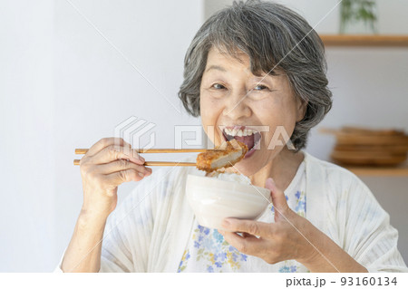 トンカツを食べるシニア女性 93160134